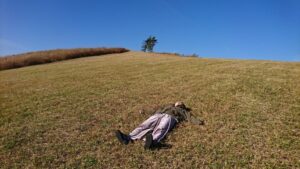 丘の芝生に寝転がる人